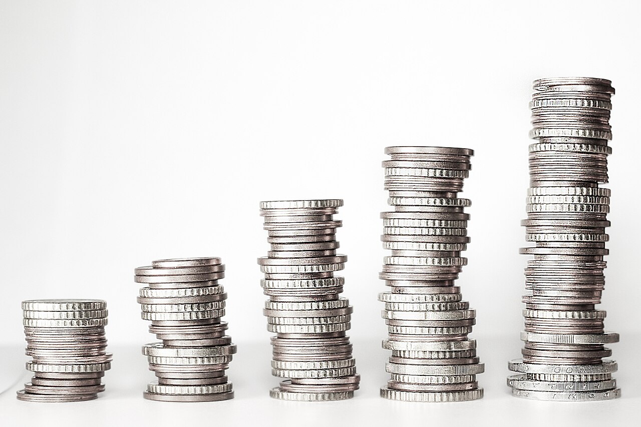 Five stacks of silver coins rising in height from left to right against a white background.
